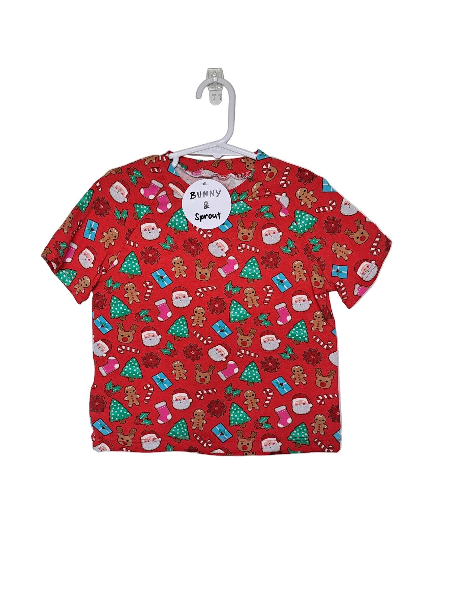 A red toddler t-shirt with a Christmas theme, featuring a pattern with Santa, reindeer, and Christmas trees.