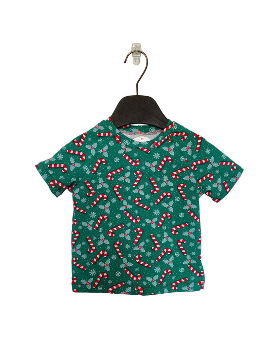 Green t-shirt with candy cane pattern on a hanger against a plain background