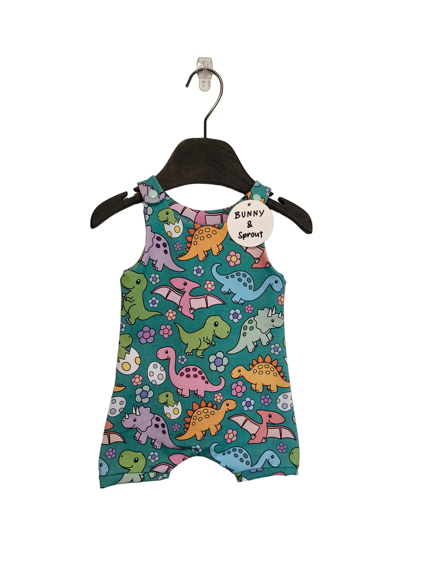Children's romper with dinosaur pattern on a hanger against a plain background