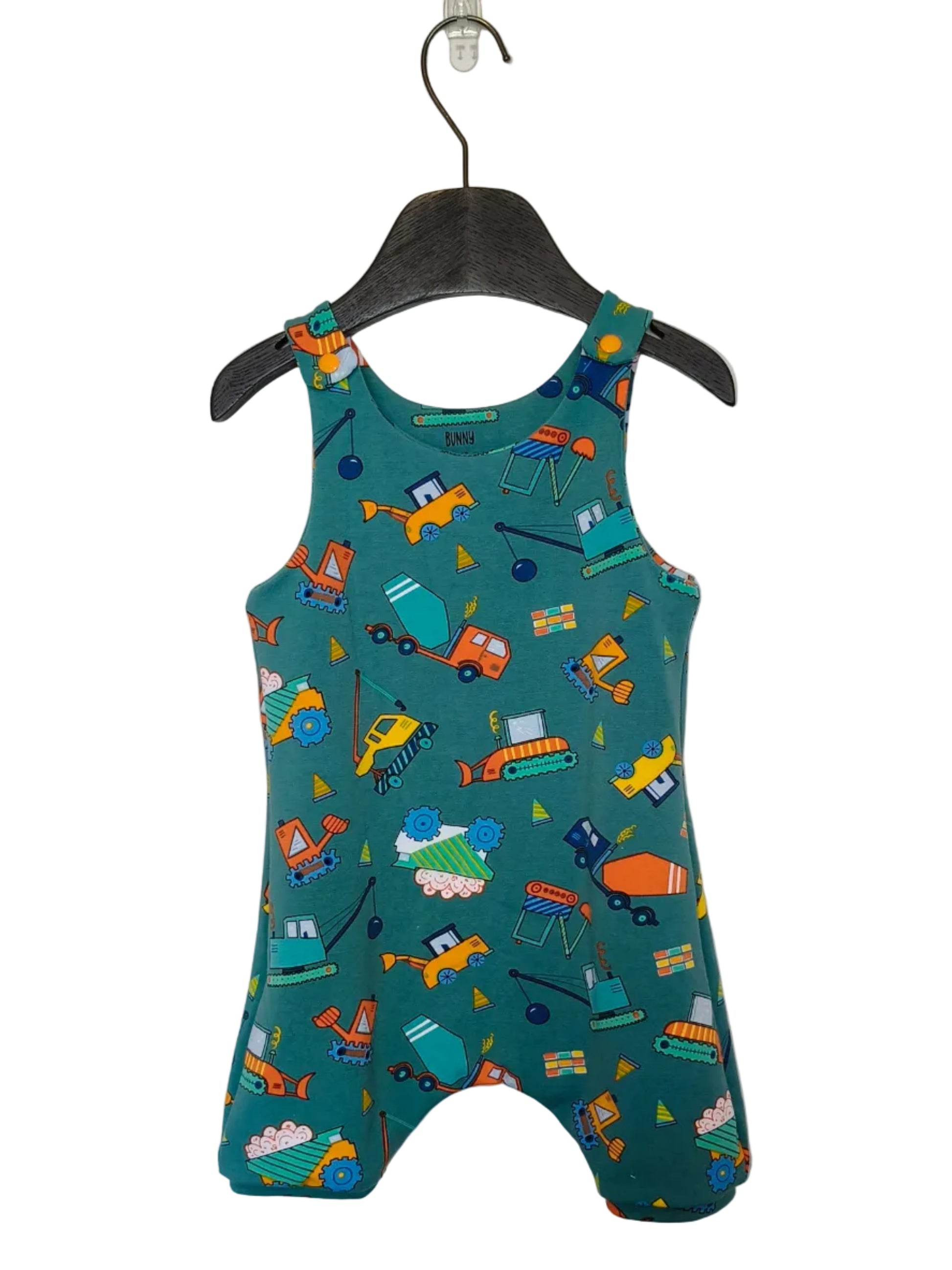 Children's romper with vehicle pattern on a hanger against a plain background